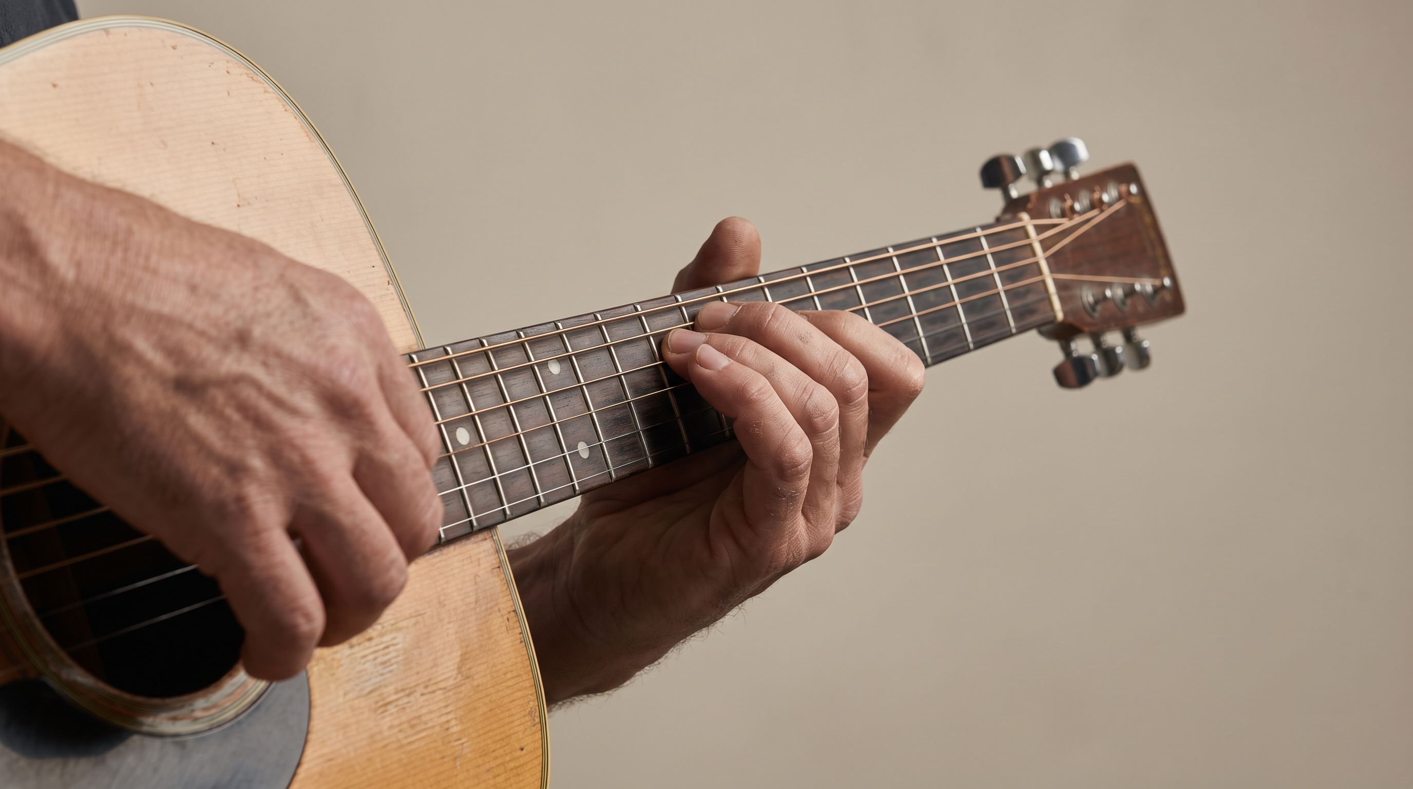 Hands changing chords on a guitar fretboard
